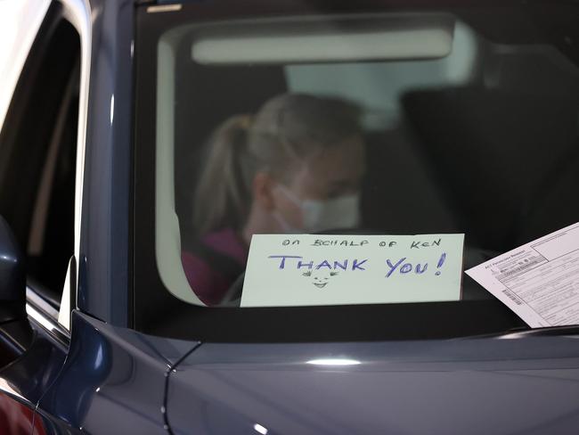 A female driver puts a “Thank you” sign in the windscreen of her car as she drives through a Covid-19 testing facility in Canberra on Sunday. Picture: NCA NewsWire / Gary Ramage