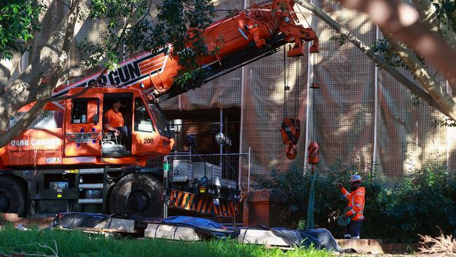 A crane tends to the trapped body at Fort Street High School, where a stone mason has been killed by falling scaffolding and concrete. Picture: Justin Lloyd.