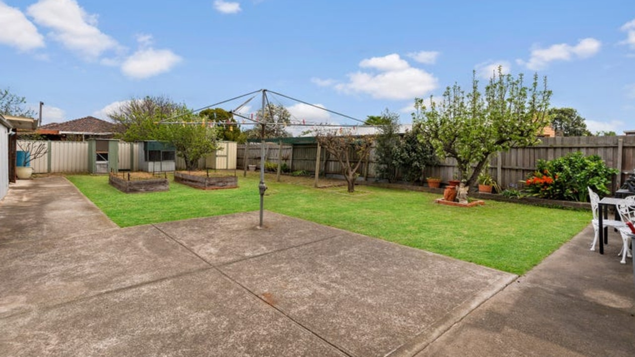 The back garden has storage sheds, planter boxes and bird cages.