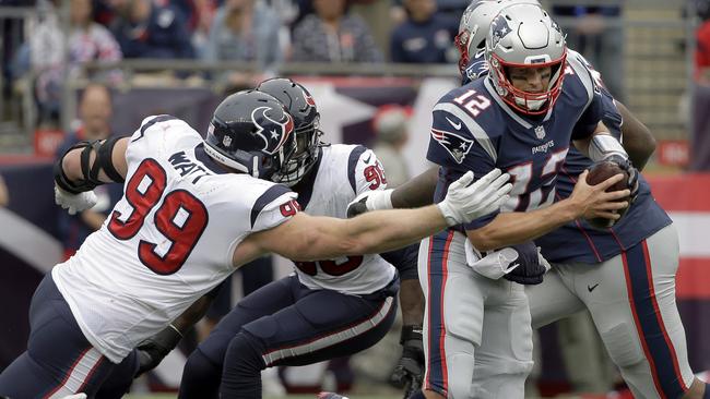 FILE - In this Sunday, Sept. 9, 2018, file photo, Houston Texans defensive end J.J. Watt (99) tries to pull down New England Patriots quarterback Tom Brady (12) during the second half of an NFL football game in Foxborough, Mass. Watt got better as the day went on his first game since breaking his leg last October. After getting through that game, the three-time Defensive Player of the Year is looking to make more of an impact this week when the Texans visit Tennessee. (AP Photo/Steven Senne, File)