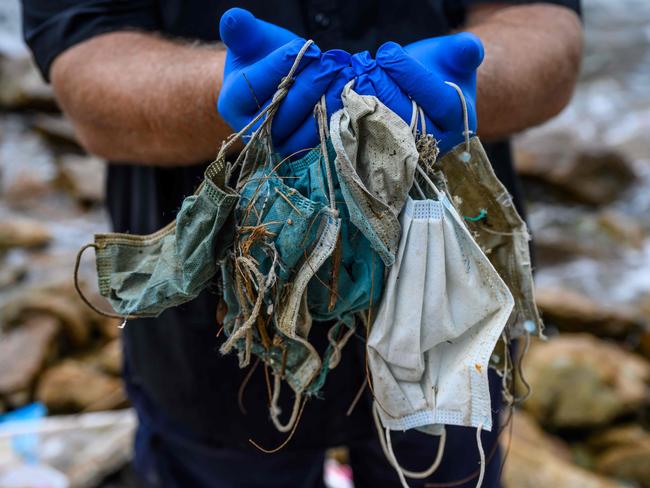 (FILES) In this file photo taken on May 13, 2020, Gary Stokes, founder of the environmental group Oceans Asia, poses with discarded face masks he found on a beach in the residential area of Discovery Bay on the outlying Lantau island in Hong Kong. - The surge in mask wearing during the coronavirus pandemic has thrown up a potent new threat to wildlife due to people thoughtlessly discarding the protective gear in massive quantities, environmentalists warn. (Photo by Anthony WALLACE / AFP)