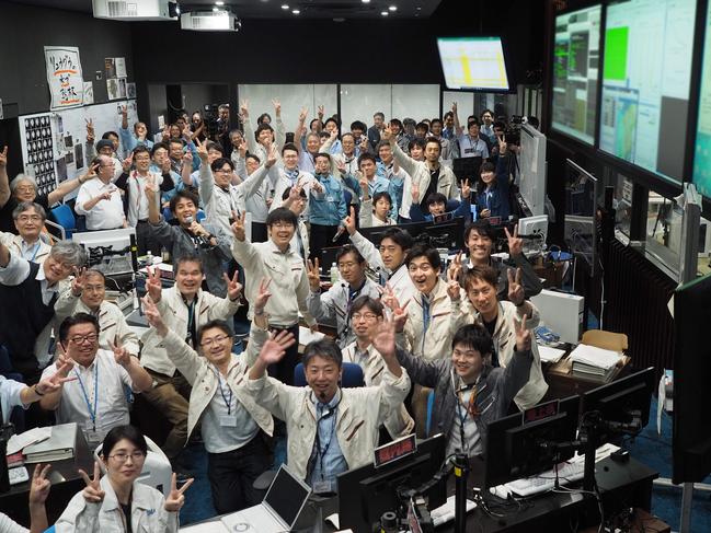 This handout photograph taken and released by the Institute of Space and Astronautical Science (ISAS) of Japan Aerospace Exploration Agency (JAXA) on July 11, 2019 shows researchers and employees celebrating after receiving confirmation of Hayabusa2's touchdown on the asteroid Ryugu, at the mission control room in Sagamihara city, Kanagawa prefecture. - Japan's Hayabusa2 probe touched down on a distant asteroid on July 11, the country's space agency said, on a mission to collect samples that could shed light on the history of the solar system. (Photo by Yutaka IIJIMA / ISAS-JAXA / AFP) / RESTRICTED TO EDITORIAL USE - MANDATORY CREDIT "AFP PHOTO / ISAS-JAXA" - NO MARKETING NO ADVERTISING CAMPAIGNS - DISTRIBUTED AS A SERVICE TO CLIENTS