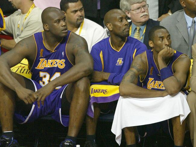 15/06/2004. Shaquille O'Neal (L), Gary Payton (C), and Kobe Bryant of the Los Angeles Lakers watch the last seconds of play as the Detroit Pistons defeat the Lakers 100-87 to win the 2004 NBA championship final, in Auburn Hills, Michigan. AFP PHOTO / Robyn BECK.