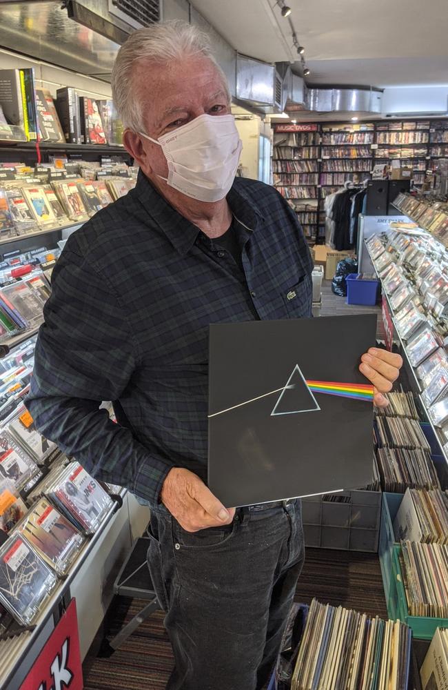 Rocking Horse Records owner Warwick Vere holding up a flood-damaged copy of Pink Floyd's <i>The Dark Side of the Moon</i>. Picture: Alex Treacy