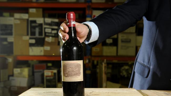 A Langton's auctioneer with a bottle of 1811 Chateau Lafite.