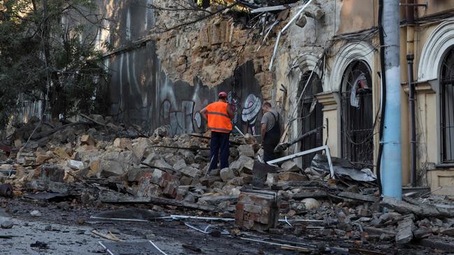 Two men stand among the rubble of a building damaged as a result of a missile strike in Odesa on July 23, 2023. At least one person was killed and more than 15 wounded in a Russian attack on the southern Ukrainian port city of Odesa, the governor of the region said. (Photo by Oleksandr GIMANOV / AFP)