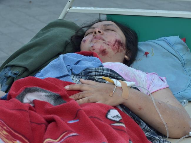 An injured quake victim waits for medical help in Mataram. Picture: AFP