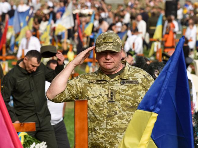 A Ukrainian officer salutes as he attends a ceremony for the fallen soldiers of Ukraine at the Lychakiv Cemetery in the western Ukrainian city of Lviv on August 24, 2022, marking six months since the start of Russia's large-scale invasion of Ukraine, which also celebrates independence Day of Ukraine. - Ukrainian President Volodymyr Zelensky on Wednesday vowed in an Independence Day address that his country would fight Russia's invasion "until the end" and would not be making "any concession or compromise". (Photo by YURIY DYACHYSHYN / AFP)