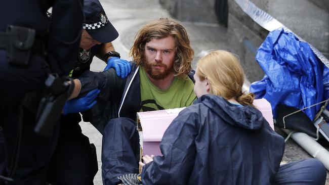 Two of the activists in a lock-on device after they were removed from the catamaran. Picture: Josh Woning/AAP