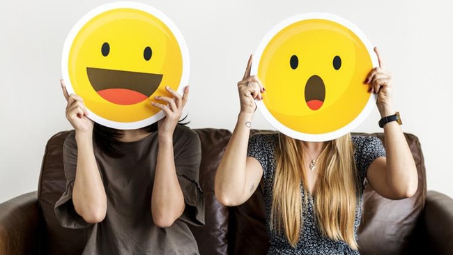 Interracial women holding an expressive emoticon face surprised and happy facial expression social media and chat concept ***These graphics are derived from our own 3D generic designs. They do not infringe on any copyright design.