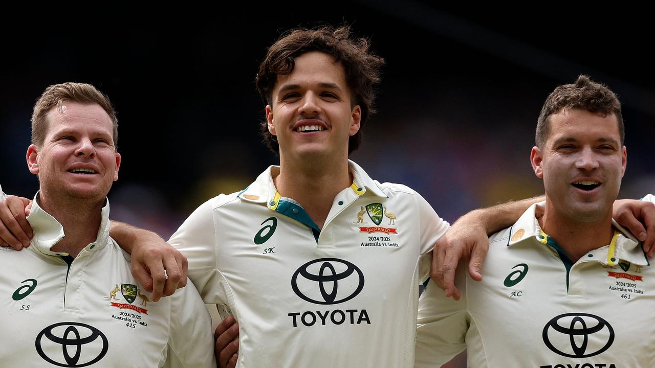 Australia's Steve Smith, Sam Konstas and Alex Carey sing the national anthem. (Photo by Martin KEEP / AFP)