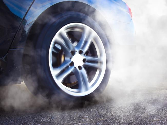 The wheels of the race car spin at speed on track and are covered with smoke, racing car drifting and burning tire , copy space , Car competition concept