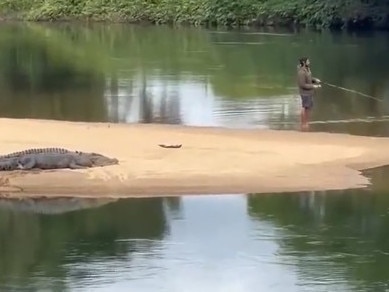 A fisho has been caught on camera flicking lures just metres from a huge croc on the Russell River.
