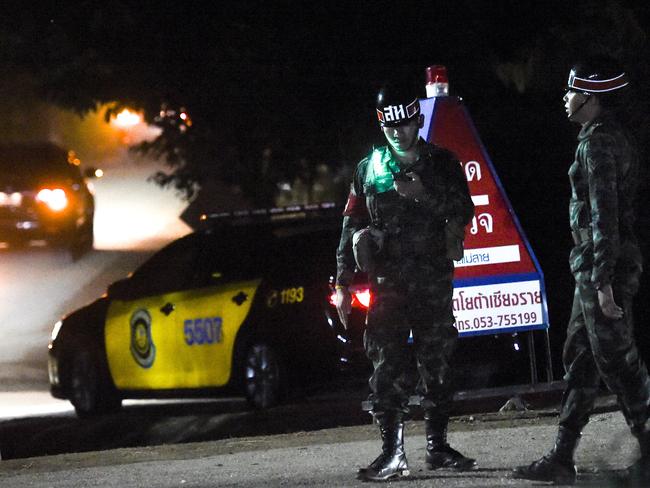 Military police secure the road as large convoy of official vehicles enter the Tham Luang cave area in Khun Nam Nang Non Forest Park in the Mae Sai district of Chiang rai province on Monday night. Picture: AFP Photo / Ye Aung Thu