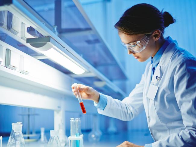 HEALTH:  Young woman working with liquids in glassware. Biotechnology research  laboratory generic