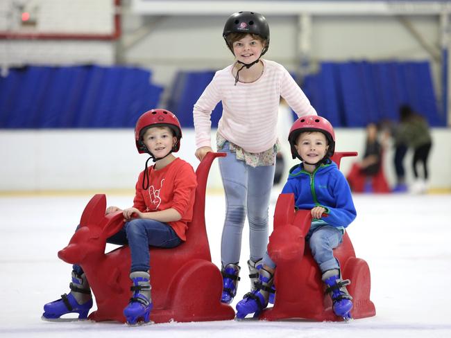 Siblings Sam, 7, Lucy, 10, and Tom McInnes, 6, at the Canterbury Olympic Ice Rink. Picture: Robert Pozo