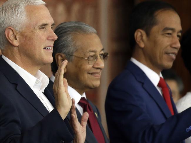 From left, Japanese Prime Minister Shinzo Abe, U.S. Vice President Mike Pence, Malaysian Prime Minister Mahathir Mohamad and Indonesia's President Joko "Jokowi" Widodo wave during a group photo at APEC Haus in Port Moresby, Papua New Guinea, Sunday, Nov. 18, 2018. (AP Photo/Mark Schiefelbein)