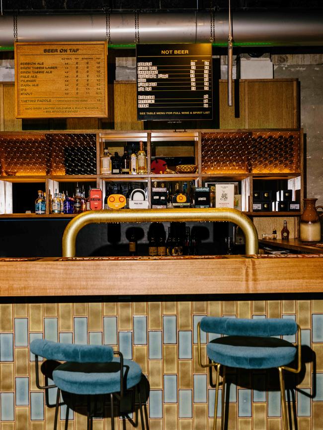 The retro interior at Manky Sally’s, which includes features such as displays of Moo Brew’s amber bottles – each containing glowing LEDs – and velvet covered bar stools. Picture: Jesse Hunniford