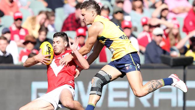 With his knee heavily strapped, Sam Lowson runs down North Adelaide’s Ben Jarman. Picture: Sarah Reed