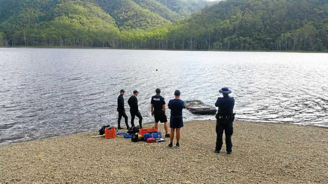 MYSTERY: Police from Imbil and the dive squad watch a car containing human remains pulled out of Borumba Dam yesterday. Picture: Contributed