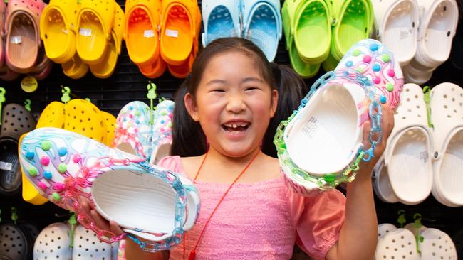 Crocs in high demand. Yiyi Zhang (7) tries on a pair at the Platypus store in Rundle Mall, Adelaide. November 27th 2023. Picture: Brett Hartwig