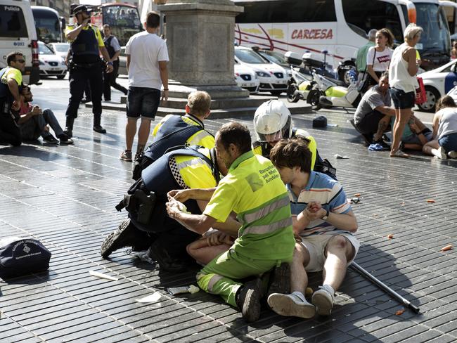 Medics and police tend to injured people near the scene of a terrorist attack in the Las Ramblas area in Barcelona, Spain. Picture: Getty