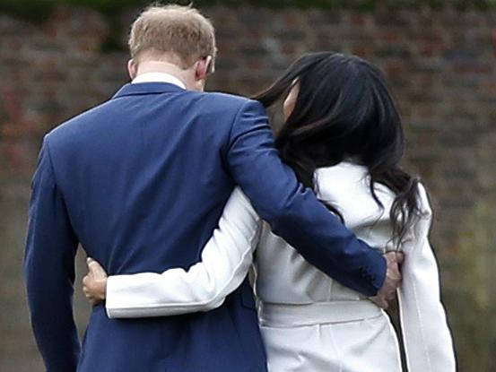 FILE - In this Monday Nov. 27, 2017 file photo Britain's Prince Harry and Meghan Markle walk away after posing for the media in the grounds of Kensington Palace in London. In a stunning declaration, Britain's Prince Harry and his wife, Meghan, said they are planning "to step back" as senior members of the royal family and "work to become financially independent." A statement issued by the couple Wednesday, Jan. 8, 2020 also said they intend to "balance" their time between the U.K. and North America. (AP Photo/Alastair Grant, File)