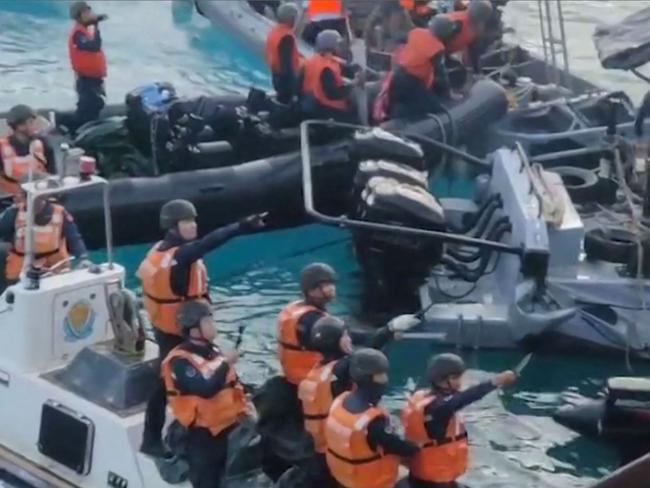 TOPSHOT - This frame grab from handout video taken on June 17, 2024 and released by the Armed Forces of the Philippines Public Affairs Office on June 19 shows China coast guard personnel appearing to wield bladed weapons during an incident off Second Thomas Shoal in the South China Sea. The Philippine military said on June 19 the Chinese coast guard rammed and boarded Filipino navy boats in a violent confrontation in the South China Sea this week in which a Filipino sailor lost a thumb. China defended its actions, with its foreign ministry saying on Wednesday that 