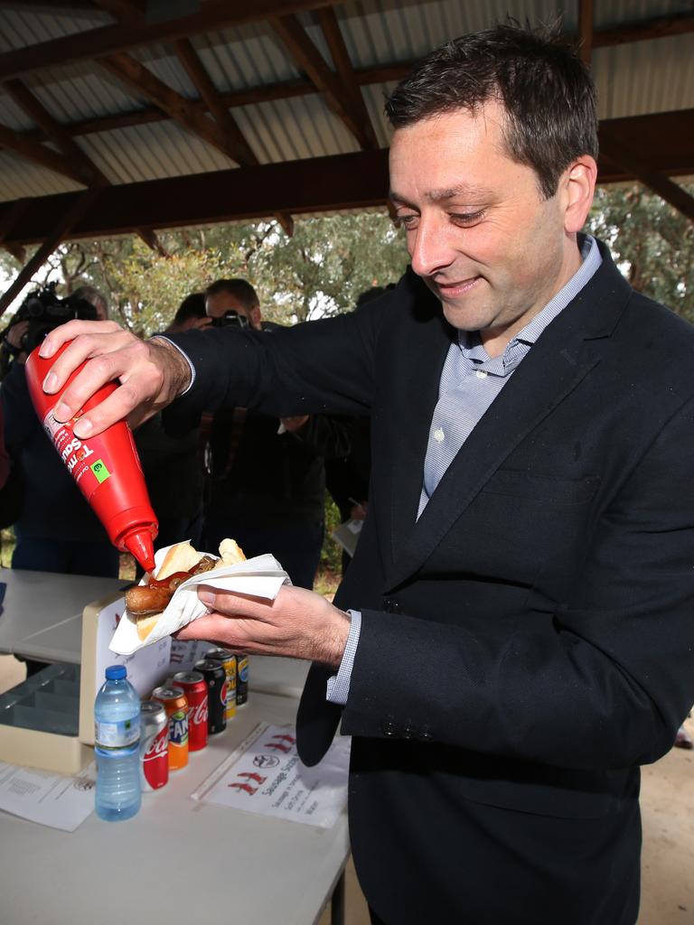 Opposition leader Matthew Guy sauces up a poll day hot dog. Picture: David Caird.