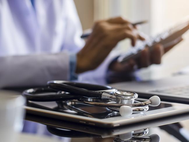 Doctor or physician using calculator and work on laptop computer with medical stethoscope and digital tablet on the desk at clinic or hospital. Medical healthcare costs ,fees and revenue concept.