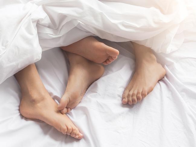 Young couple man and woman intimate relationship on bed feet