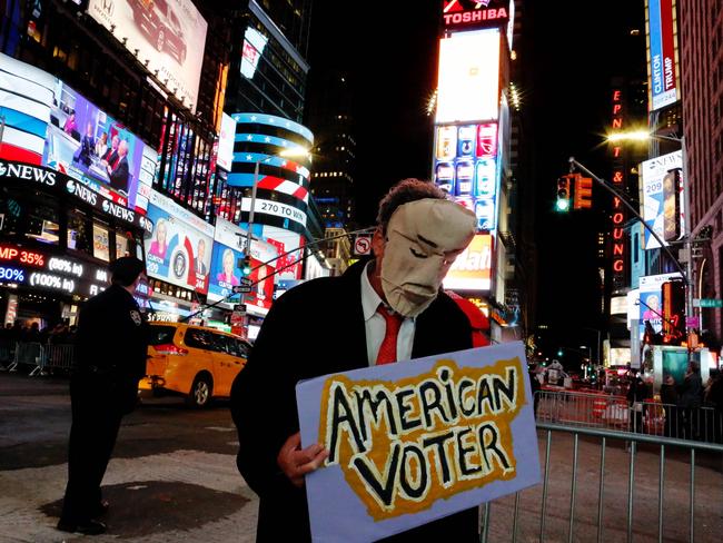 People gather around Times Square to view televised results of the US presidential election on November 9, 2016 in New York. Millions of Americans voted November 8th for their new leader in a historic election that will either elevate Democrat Hillary Clinton as their first woman president or hand power to maverick populist Donald Trump. / AFP PHOTO / EDUARDO MUNOZ ALVAREZ