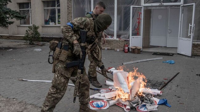 Ukrainian soldiers in Lyman burn election materials from the recent staged referendum on joining the Russian Federation. Picture: Manu Brabo for The Wall Street Journal