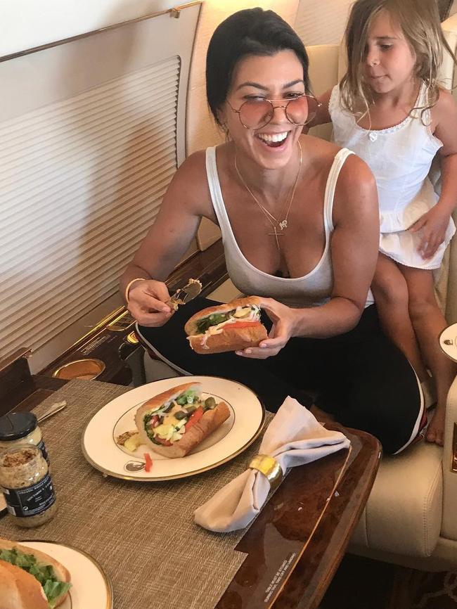 Kourtney Kardashian laughs on her private jet at the fact she's making her own lunch for once... 