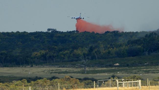 A plane disperses water over the Rosedale fire. Picture: Mark Stewart