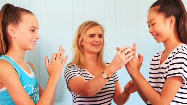 Twelve-year-olds Mia Blight and Alice Harries practise hand exercises with instructor Tarryn Byron which may be useful in preventing pain from overuse of mobile phones in the future. Picture: Tim Marsden