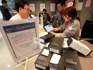 Customers return their Samsung Note 7 mobile phones at a dealership in Seoul on October 13, 2016. South Korea's central bank cut its growth outlook for next year to 2.8 percent in the wake of Samsung Electronics' damaging recall crisis and its impact on the economy. / AFP PHOTO / YONHAP / yonhap / REPUBLIC OF KOREA OUT  NO ARCHIVES  RESTRICTED TO SUBSCRIPTION USE