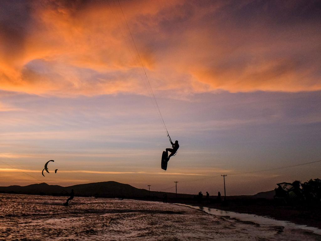 Amateur and professional kitesurfers are pictured in Cabo de la Vela, Guajira Department, Colombia, on July 4, 2016. In Cabo de la Vela, a remote destination in the extreme northeast of Colombia, members of the Wayuu indigenous tribe seek to tame the art of kitesurfing, a sport that has become a source of income in this impoverished region of the Caribbean as well as the challenge of competition. / AFP PHOTO / Joaquin Sarmiento