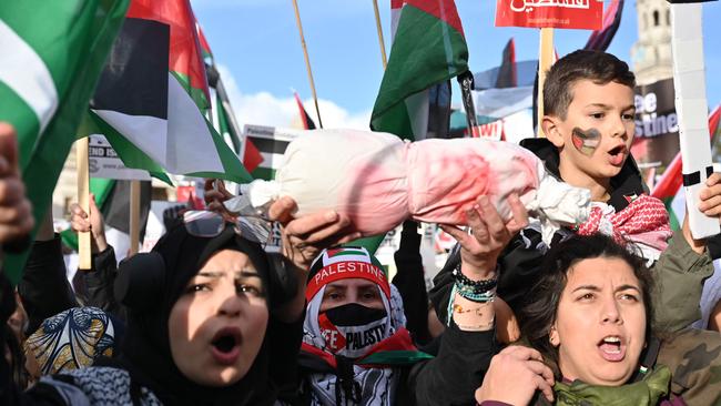 A protester holds out a bundle representing a dead baby at a pro-Palestinian rally in London. Picture: AFP