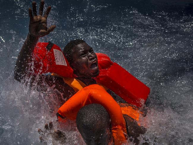 Spot News - Third Prize, Stories Picture: Mathieu Willcocks Title: Mediterranean Migration Two men panic and struggle in the water during their rescue. Their rubber boat was in distress and deflating quickly on one side, tipping many migrants in the water. They were quickly reached by rescue swimmers and brought to safety.
