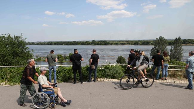 Local residents look at a partially flooded area of Kherson following damage sustained at Kakhovka HPP dam. Picture: AFP