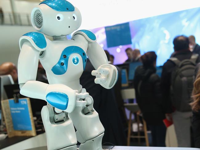 HANOVER, GERMANY - MARCH 14: A stand hostess talks to a NAO Watson robot at the IBM stand at the 2016 CeBIT digital technology trade fair on the fair's opening day on March 14, 2016 in Hanover, Germany. The 2016 CeBIT will run from March 14-18. (Photo by Sean Gallup/Getty Images)