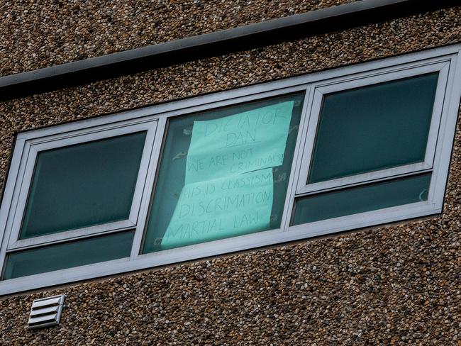 A sign is seen taped to a window of an apartment at a public housing flat in Flemington reading 'Dictator Dan we are not criminals! This is Classism Discrimination Martial law'. Picture: Getty