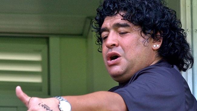 Diego Maradona gestures to Boca Junior supporters at a match in 2004. He was hospitalised after the game after suffering heart failure.