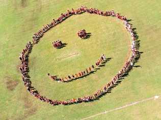 HAPPINESS: Students from Alligator Creek State School make a smiley face on the oval on the National Day of Action against Bullying and Violence. Picture: Photos by Nell