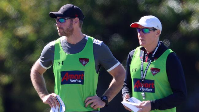 Essendon training on outside ground at Metricon Stadium on the Gold Coast. 15/07/2020. John Worsfold, senior coach of the Bombers and assistant coach Ben Rutten at training today    . Pic: Michael Klein