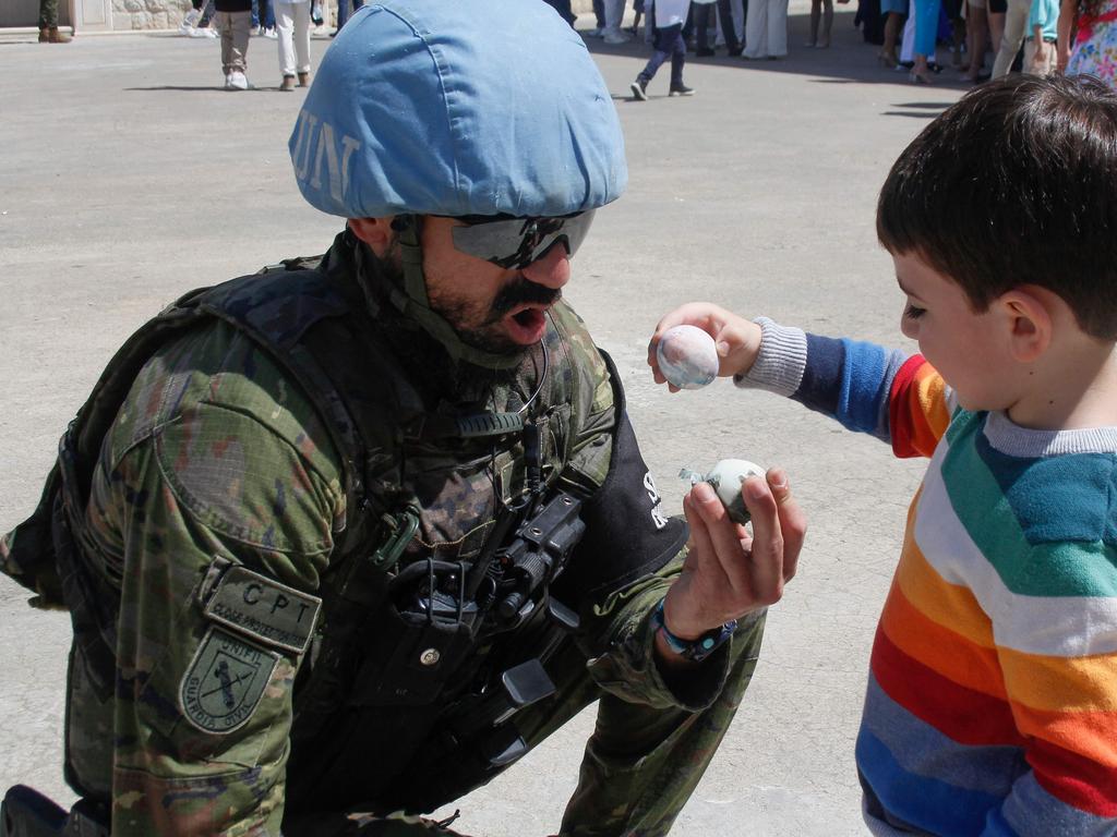 A Spanish United Nations Interim Force in Lebanon (UNIFIL) peacekeeper cracks Easter eggs with a Lebanese child outside a church in south Lebanon's Maronite Christian village of Qlayaa. Picture: AFP