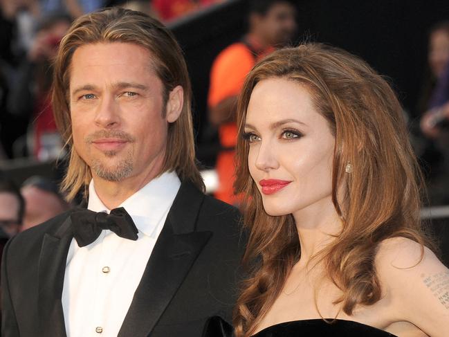 (FILES) In this file photo taken on February 25, 2012 actor Brad Pitt (L) and actress Angelina Jolie arrive at the 84th Annual Academy Awards held at the Hollywood & Highland Center in Hollywood, California. - Brad Pitt allegedly hit one of his children in the face and choked another during a fight with Angelina Jolie on a private plane, according to court papers filed October 4, 2022 in the United States by his ex-wife. (Photo by Jason Merritt / GETTY IMAGES NORTH AMERICA / AFP)