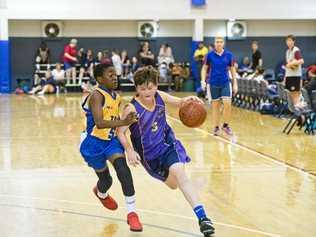 ON COURT: St Joseph's College players James Nugent (right) drives to the key during his side's Friday Night Basketball Competition match against Toowoomba Grammar School. Picture: Nev Madsen