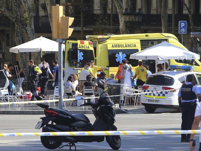 Injured people are treated in Barcelona, Spain after a white van jumped the sidewalk in the historic Las Ramblas district, crashing into a summer crowd of residents and tourists. Picture: AP